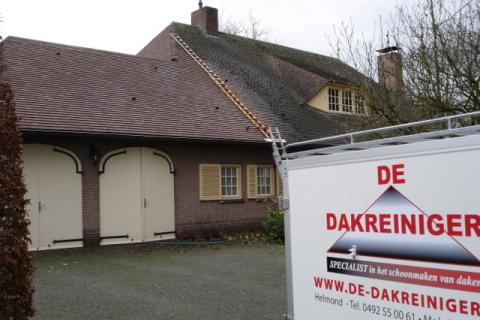 De Dakreiniger reinigt een pannen dak